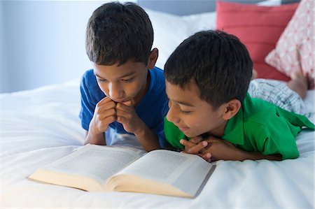 Brothers reading on bed Foto de stock - Sin royalties Premium, Código: 614-07146571