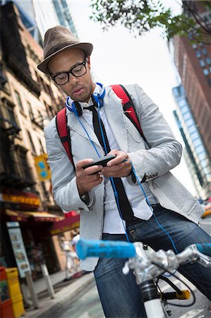 funky - Young man on bike using smartphone Stock Photo - Premium Royalty-Free, Code: 614-07146641