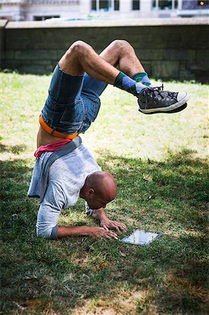 Young man doing handstand using tablet Foto de stock - Sin royalties Premium, Código: 614-07146665