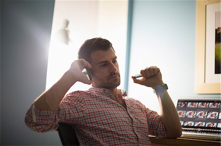 Man sitting at desk using smartphone Foto de stock - Sin royalties Premium, Código: 614-07194291