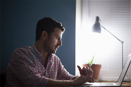 studying - Man sitting at desk typing Stock Photo - Premium Royalty-Free, Code: 614-07194293