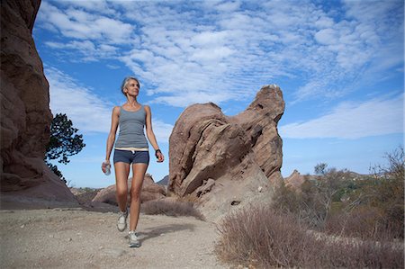 simsearch:614-07194348,k - Woman walking through Vazquez Rocks Photographie de stock - Premium Libres de Droits, Code: 614-07194348