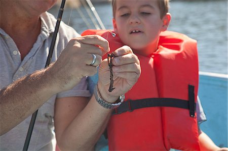 father teaching his child - Father and son on fishing trip Stock Photo - Premium Royalty-Free, Code: 614-07194354