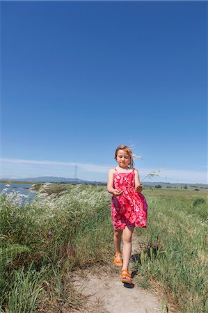 Girl walking by river marsh Stock Photo - Premium Royalty-Free, Code: 614-07194369