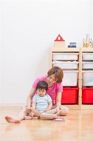 Mother reading to baby on floor Photographie de stock - Premium Libres de Droits, Code: 614-07194401