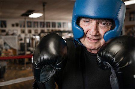 Senior man wearing boxing gloves and helmet Photographie de stock - Premium Libres de Droits, Code: 614-07194427