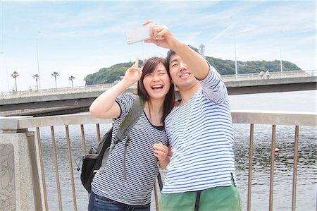 Young couple taking self portrait photograph with smartphone Photographie de stock - Premium Libres de Droits, Code: 614-07194465
