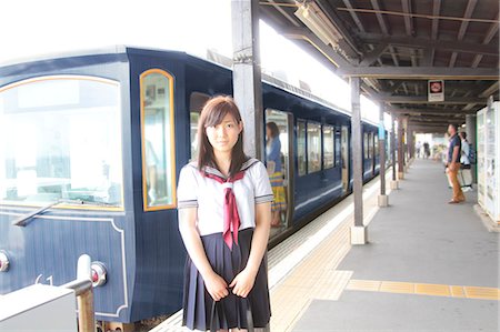 Woman wearing school uniform on railway platform at train station Stockbilder - Premium RF Lizenzfrei, Bildnummer: 614-07194487