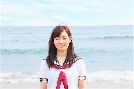 students uniform - Young woman on beach with eyes closed Stock Photo - Premium Royalty-Free, Code: 614-07194497