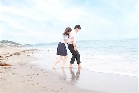 student in uniform - Young couple fooling around on beach Stock Photo - Premium Royalty-Free, Code: 614-07194504