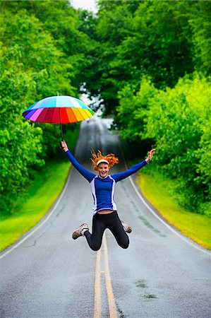 Teenage girl jumping with umbrella on road, Bainbridge Island, Washington, USA Stock Photo - Premium Royalty-Free, Code: 614-07194649