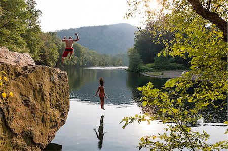 Young couple jumping from rock ledge, Hamburg, Pennsylvania, USA Stock Photo - Premium Royalty-Free, Code: 614-07194675