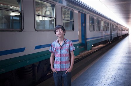 Boy by train with hands in pockets Stock Photo - Premium Royalty-Free, Code: 614-07194700
