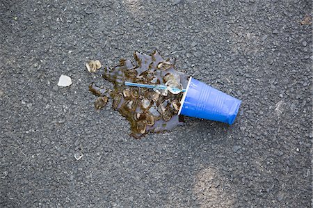 Spilled soft drink with plastic cup and ice cubes on tarmac Stock Photo - Premium Royalty-Free, Code: 614-07194720
