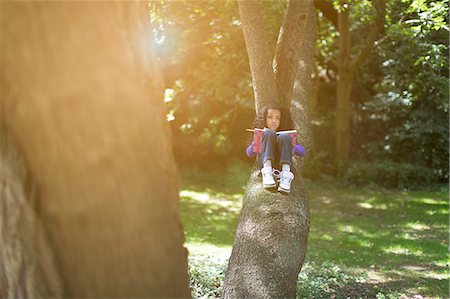 simsearch:614-07031233,k - Young girl lying on tree branch looking at book Photographie de stock - Premium Libres de Droits, Code: 614-07194738