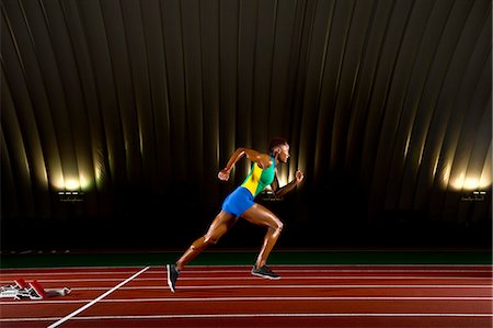 sprint - Young woman sprinting in stadium Foto de stock - Sin royalties Premium, Código: 614-07234798