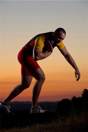 Young man preparing to throw shot put at sunset Foto de stock - Sin royalties Premium, Código: 614-07234801