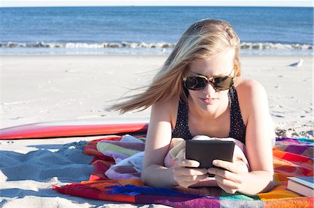 summer america beach - Young woman looking at digital tablet on beach, Breezy Point, Queens, New York, USA Stock Photo - Premium Royalty-Free, Code: 614-07234836