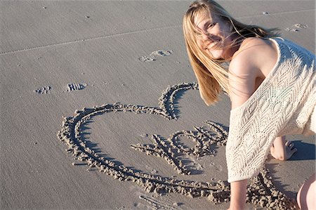 Smiling woman writing love message in sand, Breezy Point, Queens, New York, USA Photographie de stock - Premium Libres de Droits, Code: 614-07234840