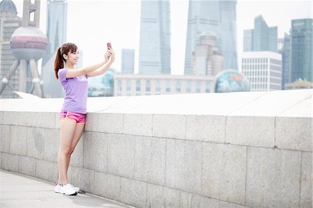 Young woman taking photograph in Shanghai, China Stock Photo - Premium Royalty-Free, Code: 614-07234859