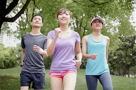 Three young people jogging in park Stock Photo - Premium Royalty-Free, Code: 614-07234867