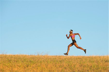 simsearch:632-06118707,k - Young woman running across field Photographie de stock - Premium Libres de Droits, Code: 614-07234906