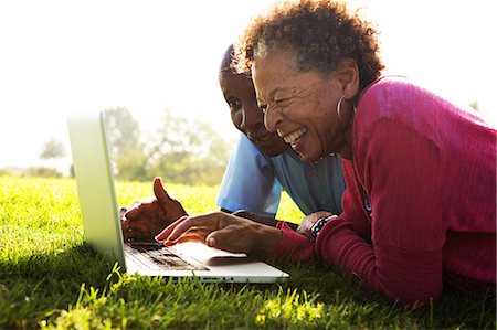 senior couples - Senior couple lying in park using laptop Stock Photo - Premium Royalty-Free, Code: 614-07234935