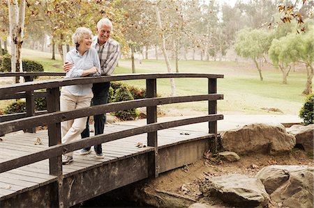 senior relax - Husband and wife chatting lovingly on bridge in the park Stock Photo - Premium Royalty-Free, Code: 614-07234963
