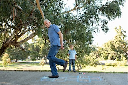 fun with grampa - Grandfather on hopscotch, boy watching Stock Photo - Premium Royalty-Free, Code: 614-07235020