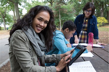 simsearch:649-07238366,k - Students sitting at table in park doing homework Fotografie stock - Premium Royalty-Free, Codice: 614-07239965