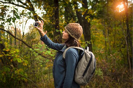 fun camping - Mature woman taking photograph in forest using smartphone Stock Photo - Premium Royalty-Free, Code: 614-07239975