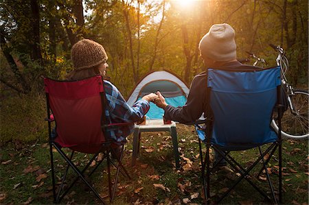 fun camping - Mature couple sitting on camping chairs outside tent, holding hands Stock Photo - Premium Royalty-Free, Code: 614-07239978