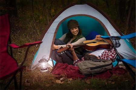 Mature couple sitting in tent, playing guitar Stock Photo - Premium Royalty-Free, Code: 614-07239983