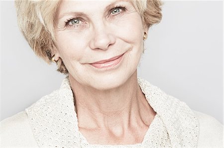 senior woman indoor portraits - Cropped studio portrait of senior woman smiling Stock Photo - Premium Royalty-Free, Code: 614-07240024