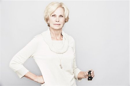 Studio portrait of senior woman holding binoculars Foto de stock - Sin royalties Premium, Código: 614-07240029