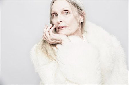 fur coats for women image - Cropped studio portrait of senior woman with hand on chin Stock Photo - Premium Royalty-Free, Code: 614-07240038