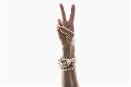 senior female white background - Studio shot of mature woman's hand making peace gesture Stock Photo - Premium Royalty-Free, Code: 614-07240052