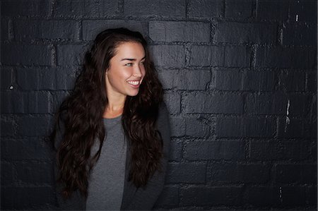 Young woman by black brick wall Photographie de stock - Premium Libres de Droits, Code: 614-07240136