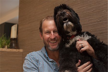 Portrait of mature man holding up pet dog Photographie de stock - Premium Libres de Droits, Code: 614-07240153
