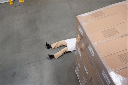 Man lying on floor with cardboard boxes in warehouse Stock Photo - Premium Royalty-Free, Code: 614-07240169