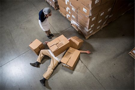 fallen (bewegung nach unten) - Woman looking at man lying on floor covered by cardboard boxes in warehouse Stockbilder - Premium RF Lizenzfrei, Bildnummer: 614-07240171