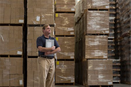 Man holding clipboard in warehouse Fotografie stock - Premium Royalty-Free, Codice: 614-07240172