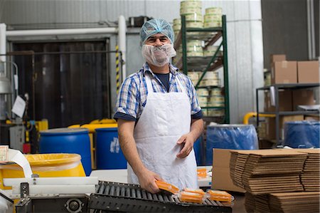 person in a food factory in hair net - Man packaging vegan cheese in warehouse Photographie de stock - Premium Libres de Droits, Code: 614-07240184