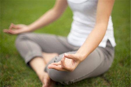 female yoga outdoors - Cropped image of young woman in park practicing lotus position Stock Photo - Premium Royalty-Free, Code: 614-07444019