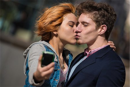 Couple taking selfies in the city Stock Photo - Premium Royalty-Free, Code: 614-07444124