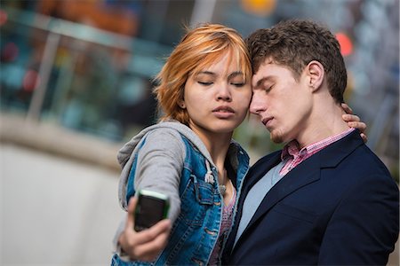 Couple taking selfies in the city Stock Photo - Premium Royalty-Free, Code: 614-07444125