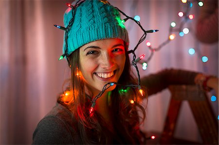 Portrait of young woman wrapped in christmas lights Stock Photo - Premium Royalty-Free, Code: 614-07444164