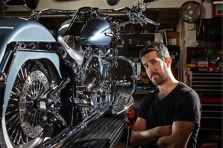 Portrait of mid adult man in motorcycle repair workshop Stock Photo - Premium Royalty-Free, Code: 614-07444181