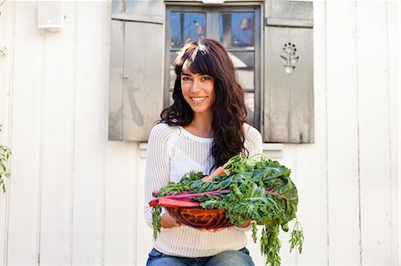 Portrait of young woman holding homegrown vegetables Stock Photo - Premium Royalty-Free, Code: 614-07444226