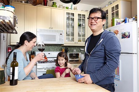 drinking wine in home - Mature couple in kitchen with young daughter Stock Photo - Premium Royalty-Free, Code: 614-07444248